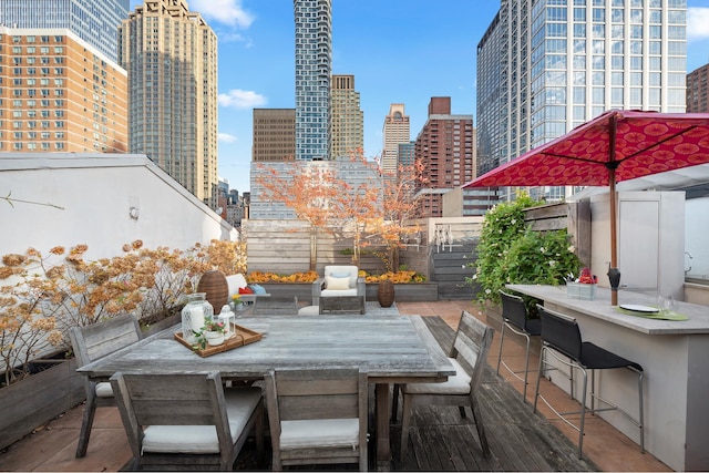 view of patio / terrace featuring a view of city, outdoor dry bar, outdoor dining space, and fence private yard