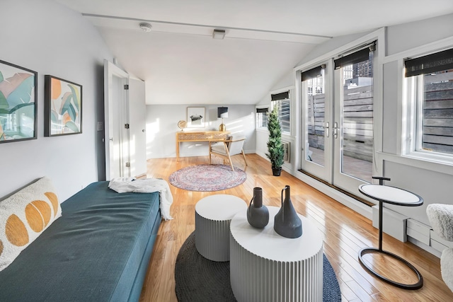 living room with vaulted ceiling, french doors, and wood-type flooring