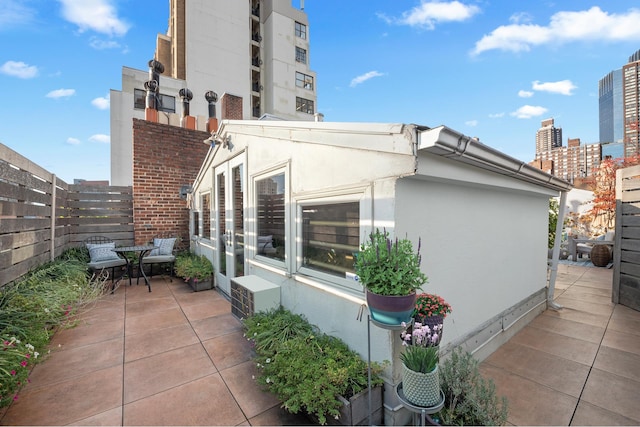 view of home's exterior featuring a fenced backyard, a patio, a city view, and stucco siding