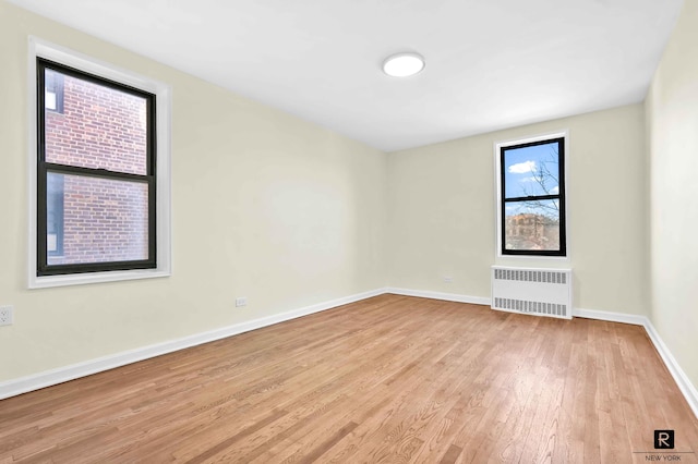 10 E 43rd St Unit 4-K, New York City, NY 11203 - empty room featuring radiator, wood finished floors, and baseboards