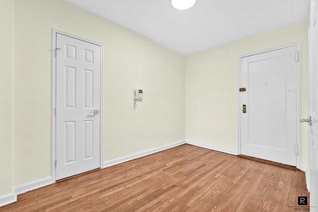 unfurnished room featuring baseboards and light wood finished floors