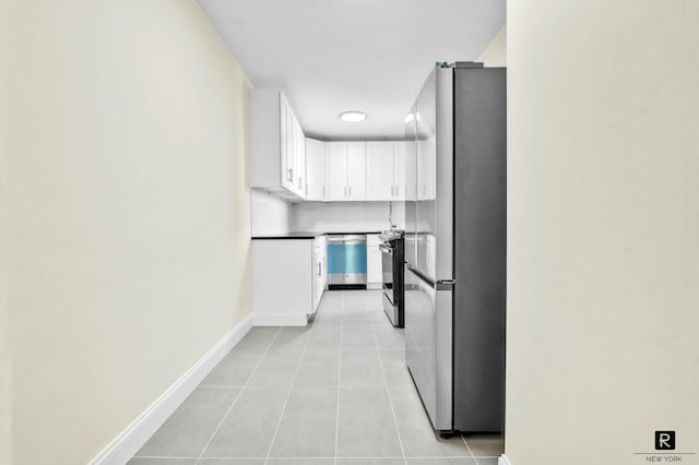 10 E 43rd St Unit 4-K, New York City, NY 11203 - kitchen with appliances with stainless steel finishes, light tile patterned flooring, white cabinets, and baseboards