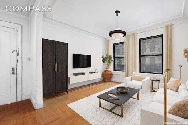 living area featuring crown molding and baseboards