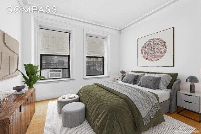 bedroom featuring crown molding, light wood-style floors, and cooling unit