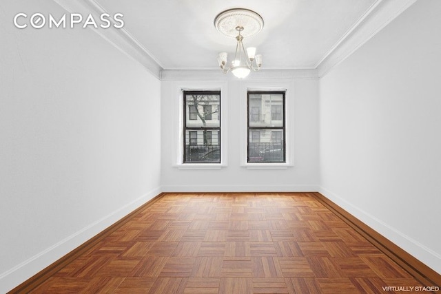 unfurnished room with ornamental molding, baseboards, and a chandelier