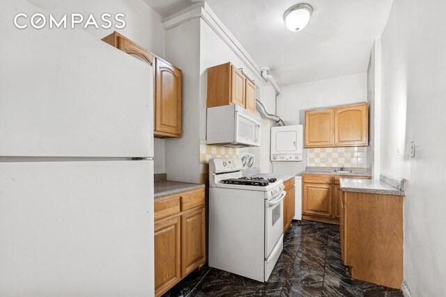 kitchen with tasteful backsplash, light countertops, a sink, marble finish floor, and white appliances