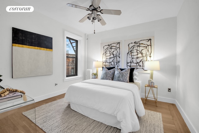 bedroom with radiator, visible vents, baseboards, and wood finished floors