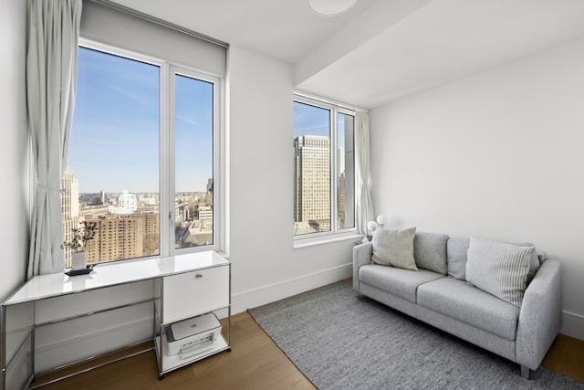 office area with a view of city, baseboards, and wood finished floors