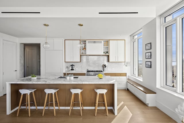 1 Clinton St Unit 19A, New York City, NY 11201 - kitchen featuring light wood finished floors, open shelves, decorative backsplash, white cabinets, and range