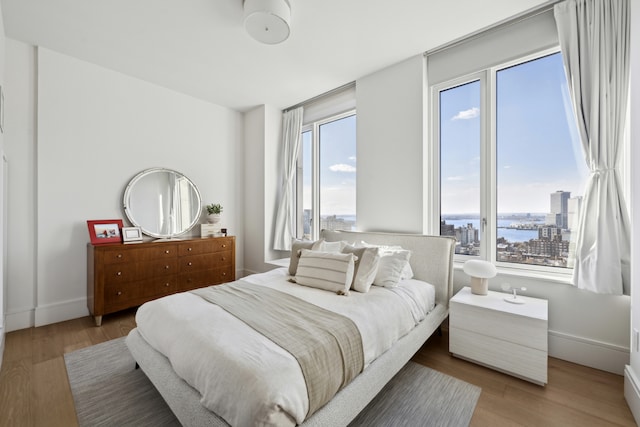 bedroom with light wood-type flooring and baseboards