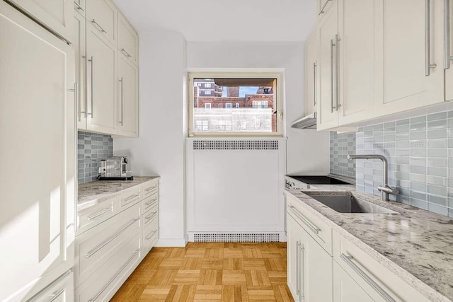 19 E 88th St Unit 15G, New York City, NY 10128 - kitchen with a sink, paneled fridge, white cabinets, and backsplash
