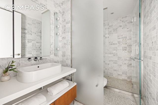 85 W Broadway Unit 14S, New York City, NY 10007 - full bathroom with vanity, a tile shower, toilet, tile patterned floors, and tile walls