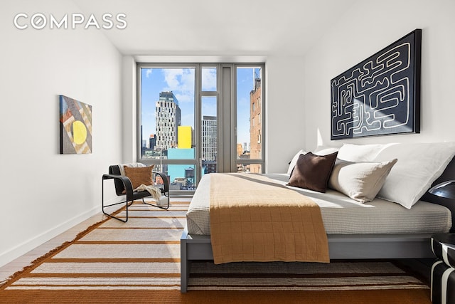 85 W Broadway Unit 14S, New York City, NY 10007 - bedroom featuring a skyline view, baseboards, access to outside, and wood finished floors