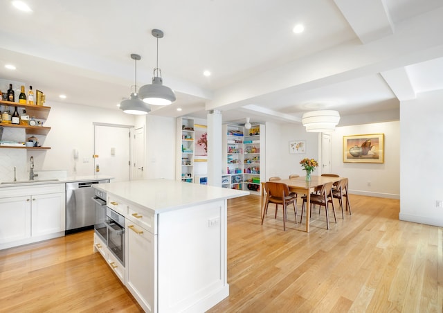 kitchen with a sink, white cabinets, appliances with stainless steel finishes, open shelves, and light wood finished floors