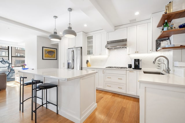 kitchen with tasteful backsplash, open shelves, appliances with stainless steel finishes, exhaust hood, and recessed lighting