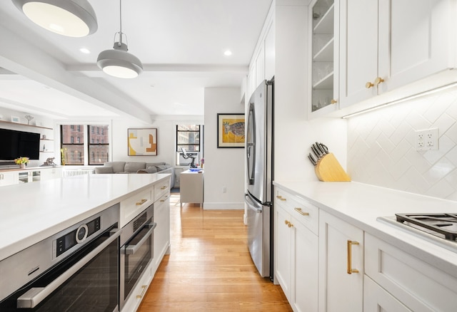 kitchen with glass insert cabinets, decorative backsplash, stainless steel appliances, light wood finished floors, and open floor plan
