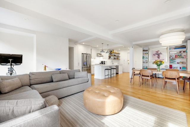 living area with light wood-type flooring, beam ceiling, and recessed lighting