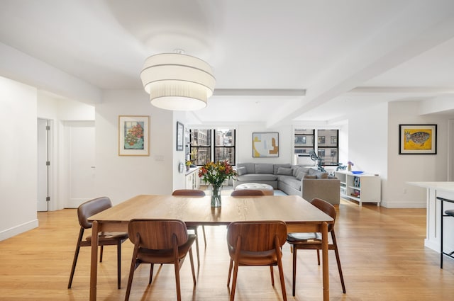 dining room featuring light wood finished floors and baseboards