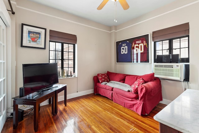 living room featuring hardwood / wood-style floors, baseboards, and ceiling fan