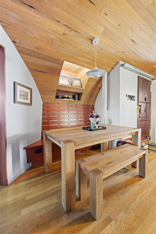 unfurnished dining area with lofted ceiling, light wood-type flooring, and wooden ceiling