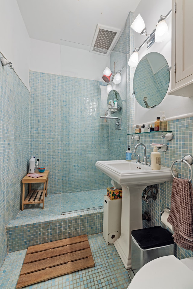 bathroom featuring visible vents, toilet, tile patterned floors, walk in shower, and tile walls