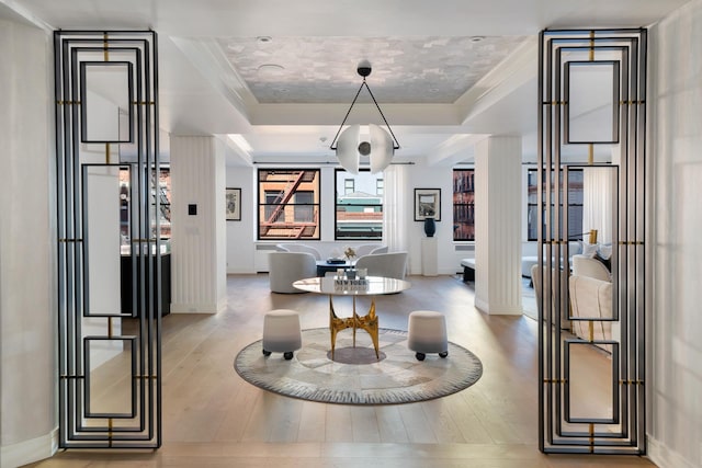 dining room featuring wood-type flooring, a tray ceiling, and baseboards