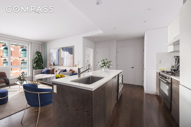 kitchen with a sink, light countertops, dark brown cabinets, high end stainless steel range, and modern cabinets