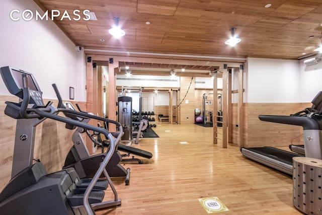 workout area featuring light wood-style floors and wood ceiling