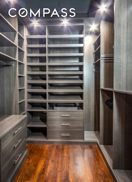 walk in closet with dark wood-style flooring