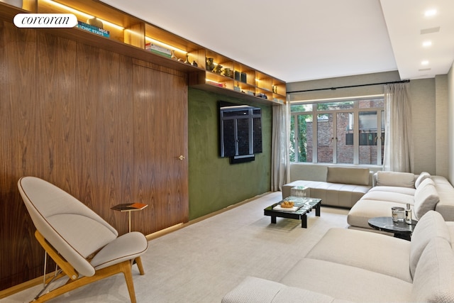 living room featuring wood walls and carpet