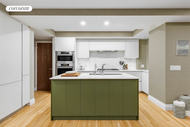 kitchen featuring light wood finished floors, stainless steel appliances, visible vents, green cabinets, and white cabinets