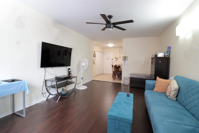 living room featuring wood finished floors, a ceiling fan, and baseboards