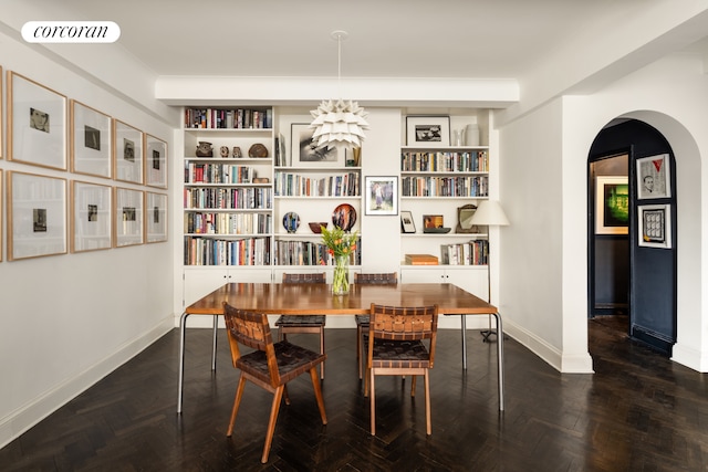 dining space with arched walkways, visible vents, and baseboards