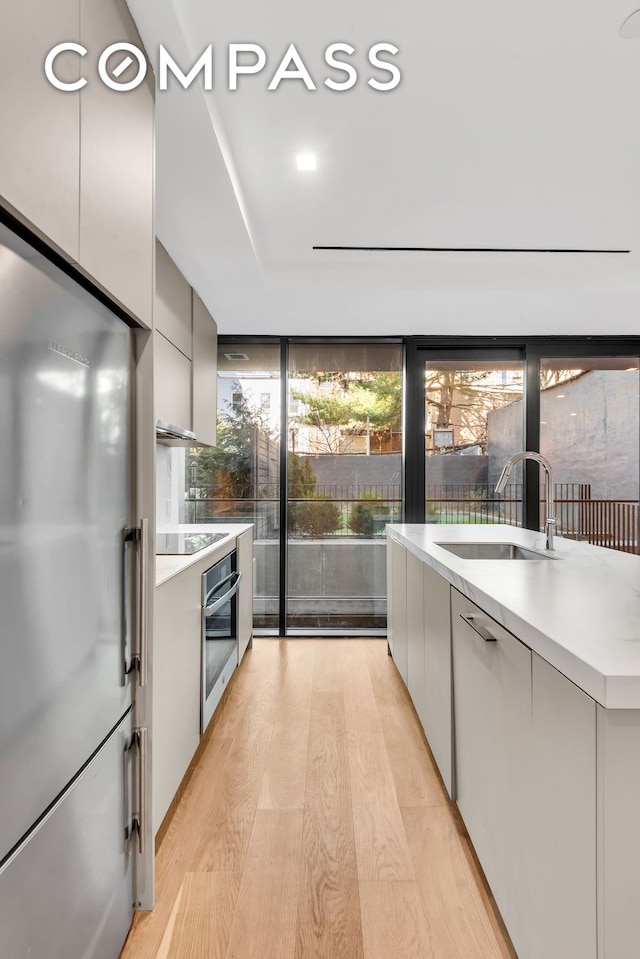 kitchen featuring plenty of natural light, modern cabinets, appliances with stainless steel finishes, and a sink