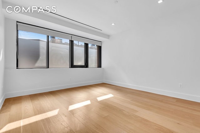 empty room with baseboards and wood finished floors