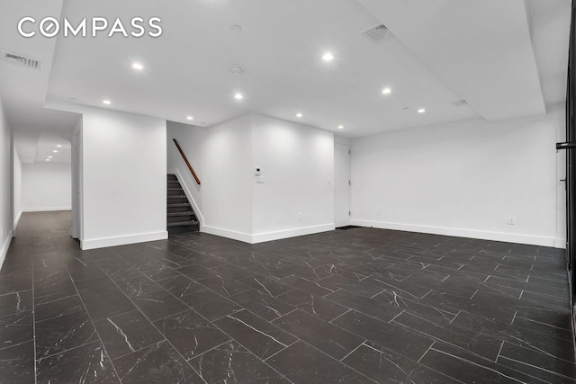 below grade area with visible vents, stairway, baseboards, and recessed lighting