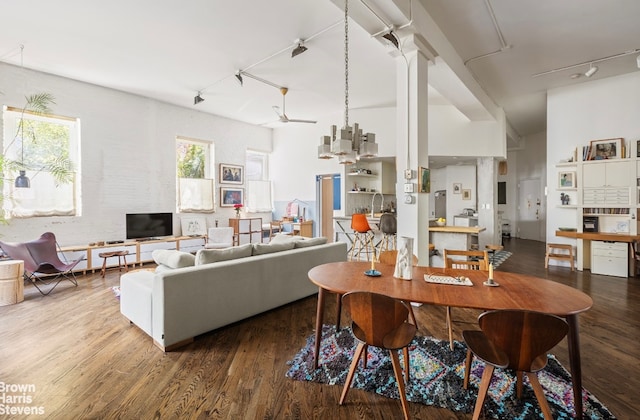 dining area featuring a chandelier, rail lighting, and wood finished floors