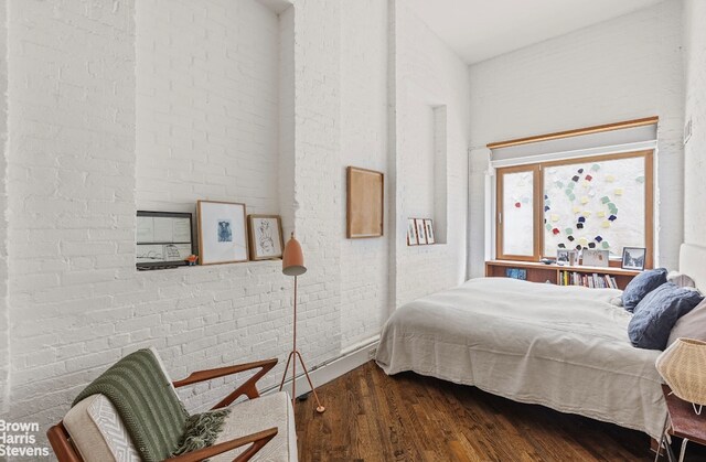 bedroom with a towering ceiling and dark wood-type flooring