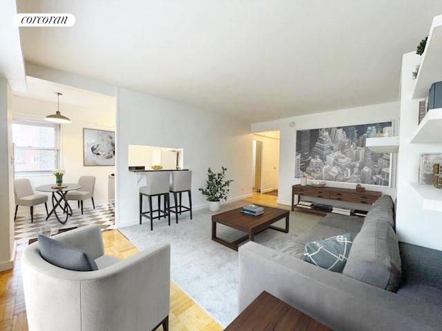 living room with baseboards, visible vents, and wood finished floors