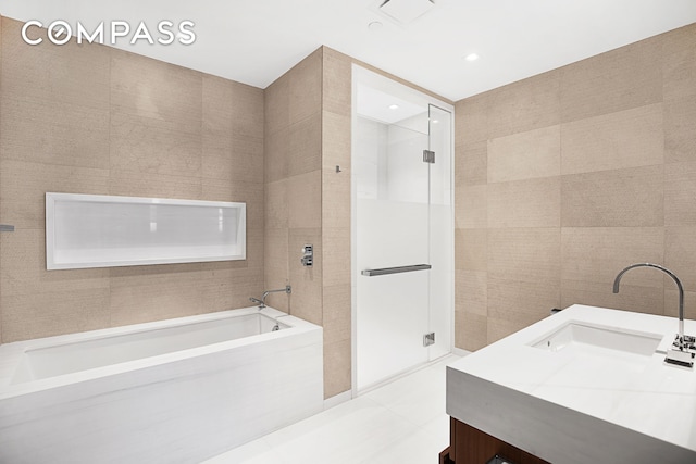 full bathroom with visible vents, a sink, tile walls, tile patterned flooring, and a bath