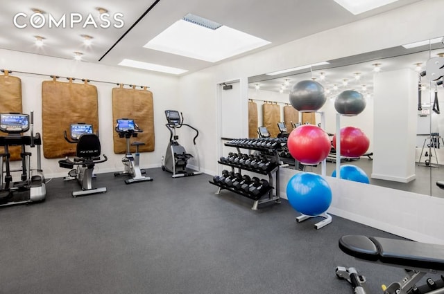 gym with a skylight, visible vents, and baseboards