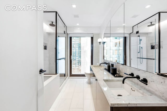 bathroom featuring toilet, a sink, visible vents, double vanity, and a stall shower