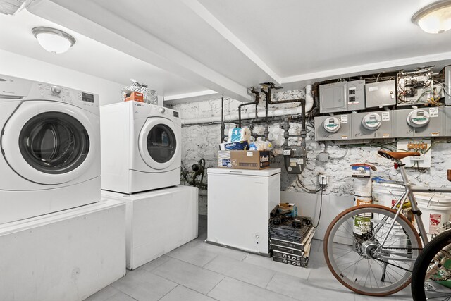 867 Lafayette Ave, New York City, NY 11221 - laundry room featuring washer and clothes dryer, light tile patterned floors, and electric panel