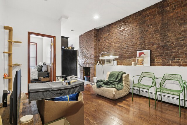 867 Lafayette Ave, New York City, NY 11221 - living room featuring a fireplace, wood-type flooring, and brick wall