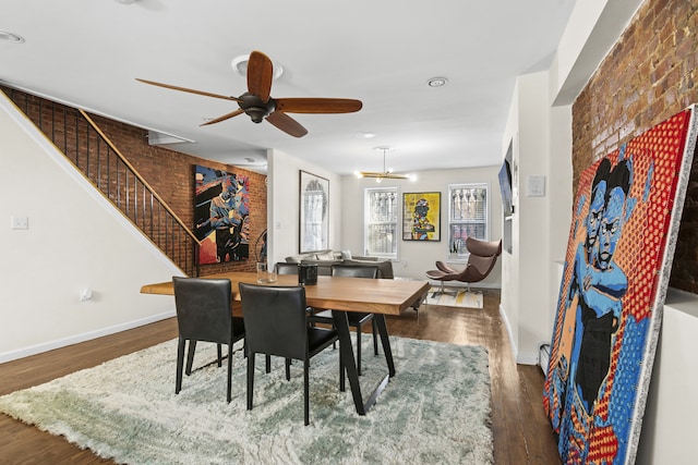 dining space featuring a healthy amount of sunlight, brick wall, and wood finished floors