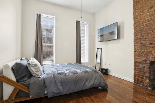 bedroom featuring multiple windows, wood finished floors, and baseboards