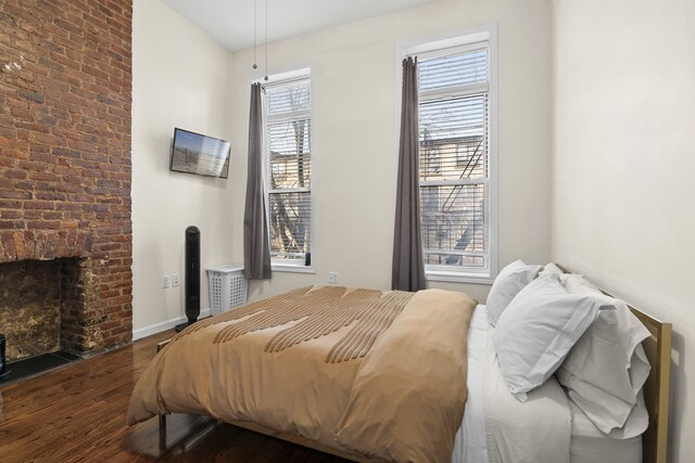 867 Lafayette Ave, New York City, NY 11221 - bedroom featuring wood finished floors, baseboards, and a brick fireplace