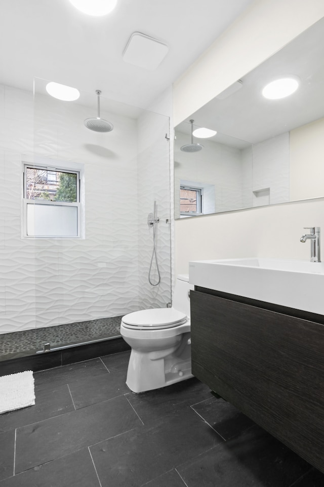 bathroom featuring toilet, vanity, and a walk in shower