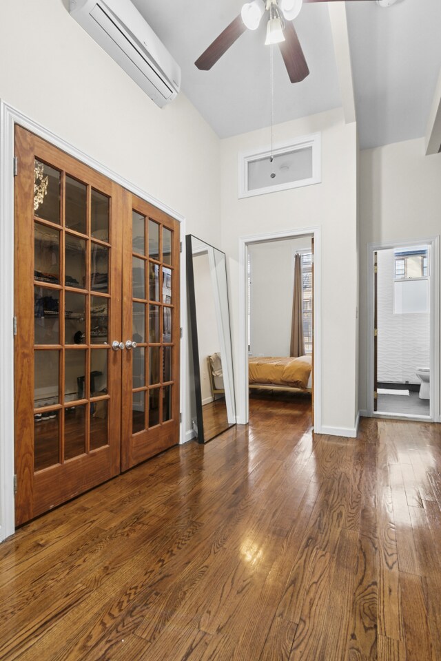 867 Lafayette Ave, New York City, NY 11221 - spare room with a wall mounted air conditioner, a ceiling fan, a high ceiling, wood finished floors, and french doors