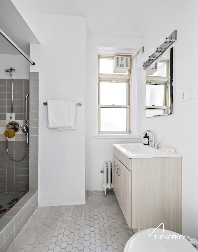 full bath featuring radiator heating unit, a tile shower, visible vents, and tile patterned floors